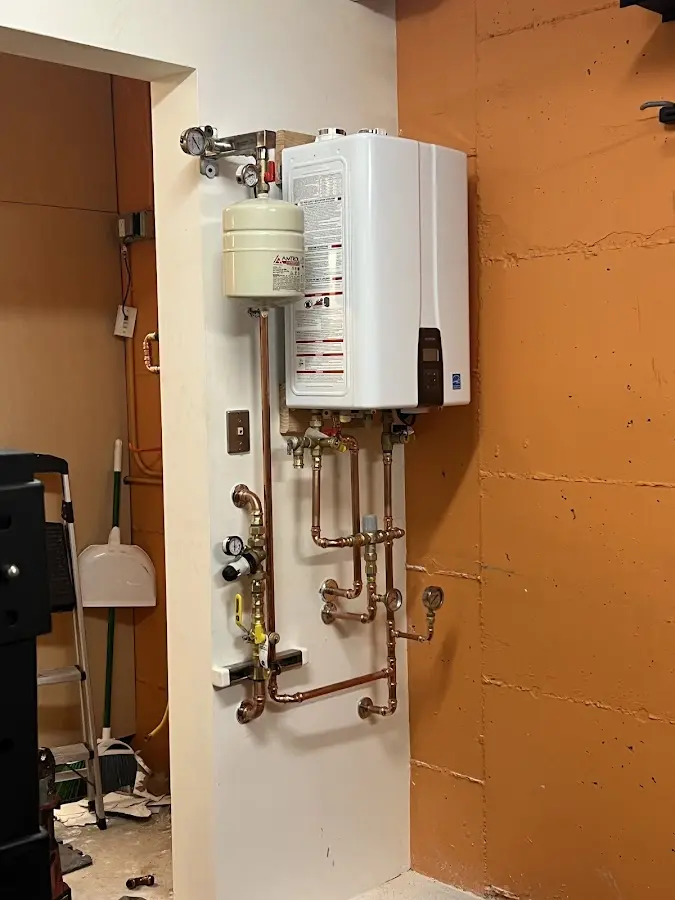 Plumbing technician inspecting water heater connections in Lockport